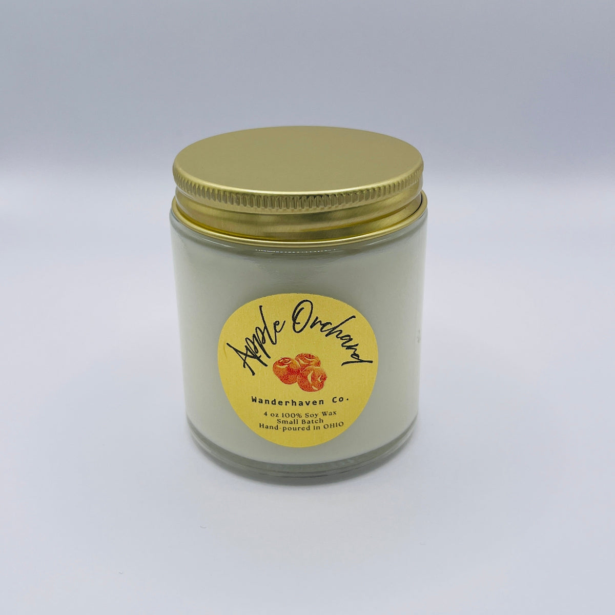 Small 4 oz Jar has a gold lid with clear glass gar and circle old label with apples and apple orchard written across